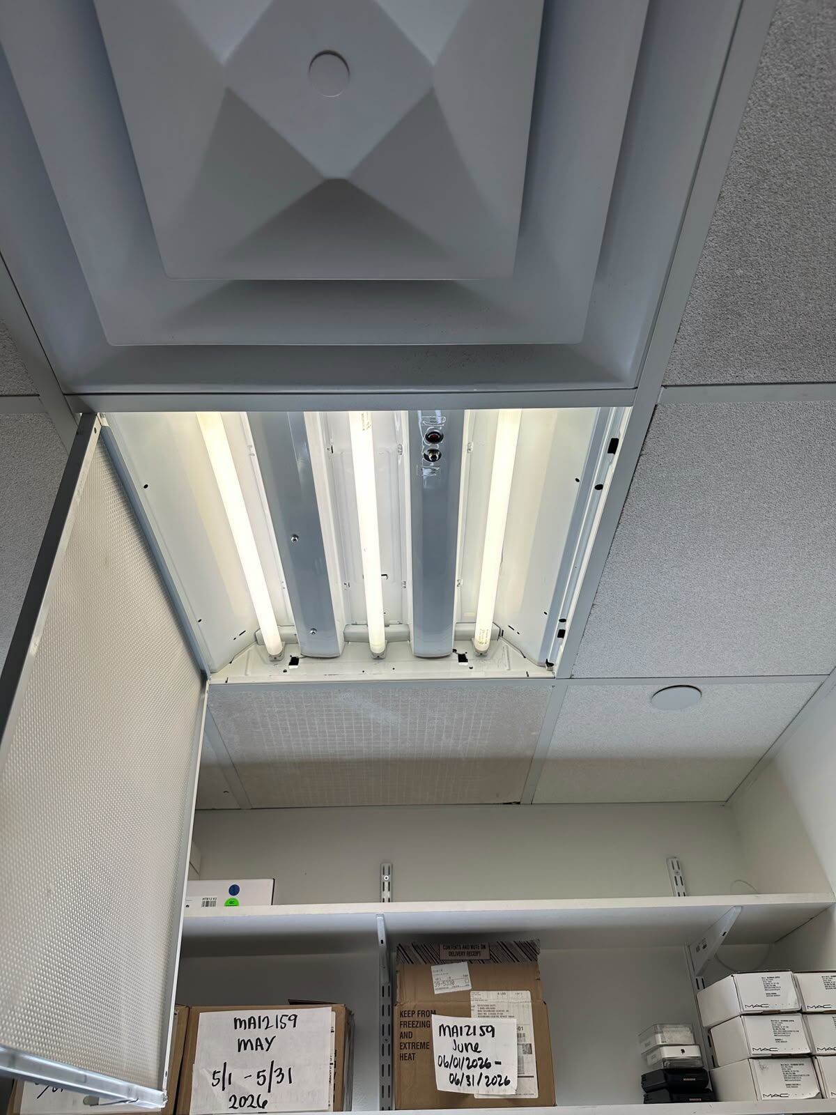 Ceiling light fixture opened for relamping and repair